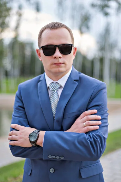 Portrait of a young serious businessman in blue suit and sunglasses — Stock Photo, Image