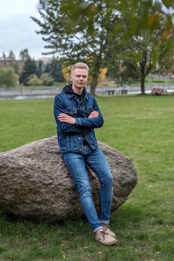 bir taş nehir ile parkta oturan yakışıklı erkekler