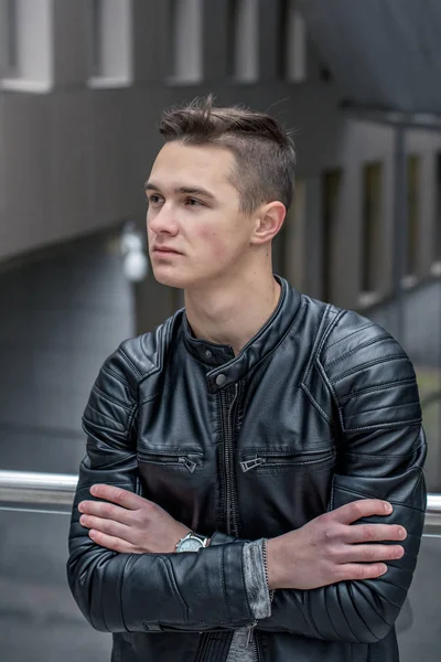 Serious young student in a black Leather Jacket outside a university — Stock Photo, Image