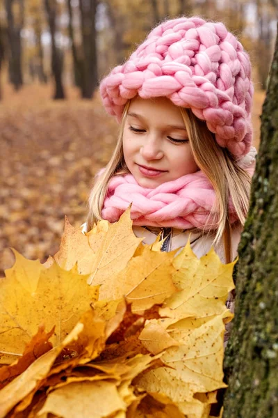 Дівчина мрійливо дивиться на букет кленового листя — стокове фото