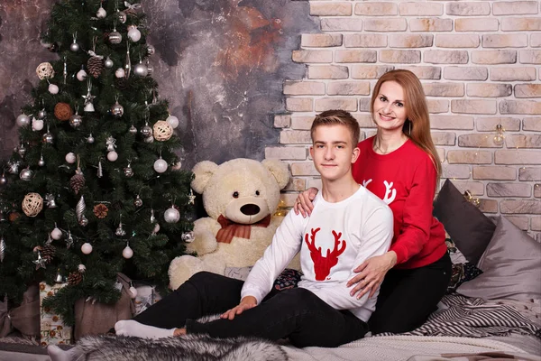 Portré egy fiatal anyáról tinédzser fiával kényelmes ruhában az újévi fa mellett — Stock Fotó