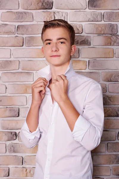 Close portrait of teenage boy in shirt near brick wall in studio Royalty Free Φωτογραφίες Αρχείου