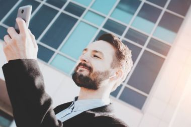 Modern kablosuz kulaklık sakallı hippi müziği dinliyor ve açık üzerinde yürüyor