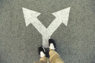 Double arrow painted on an asphalt road. Top view of the legs and shoes. POV clipart