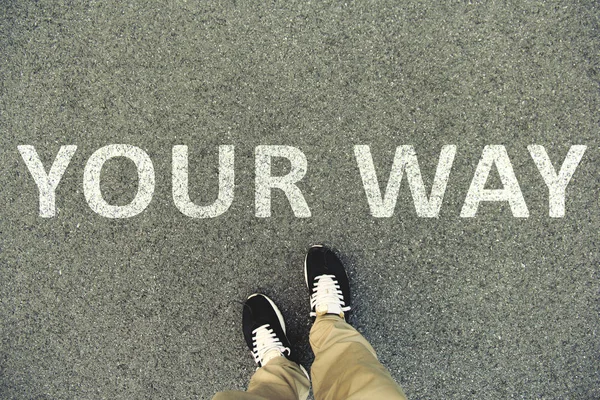 Palavras "O seu caminho" escritas em uma estrada de asfalto. Vista superior das pernas e sapatos. VPO — Fotografia de Stock