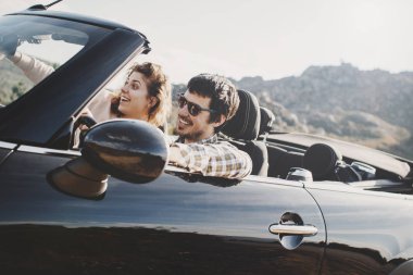 Sıcak güneşli bir günde serpantin bir dağda bir cabriolet sürme güzel genç Çift