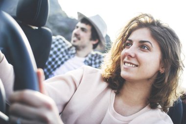 Güzel kız bir cabriolet direksiyon başında oturur ve onun arkadaşı arka koltukta oturur