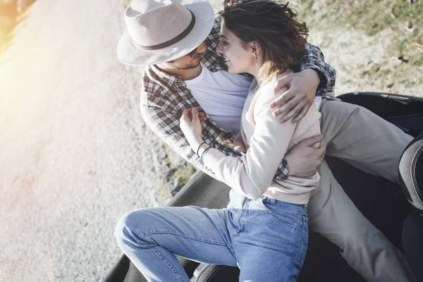 Happy and passionate couple hugs in the back seat of a cabriolet — Stock Photo, Image