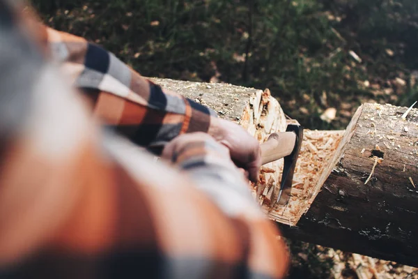 Woodcutter in a plaid shirt and a sharp ax in the hands of a close-up is going to cut a tree — Stock Photo, Image