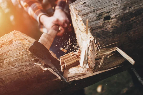 Strong lumberjack chopping wood in the forest, chips fly apart. Lens flare effect — Stock Photo, Image