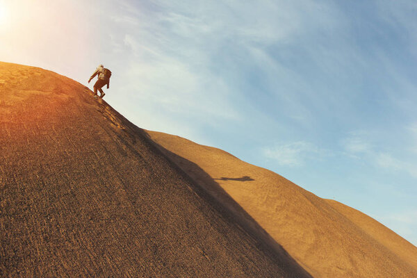 Man in the desert rises on the dune
