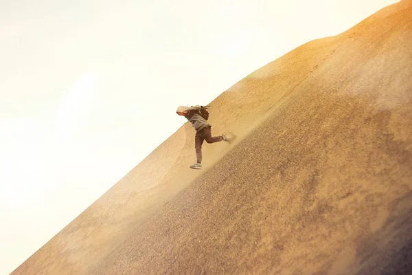 Хоробрий чоловік з рюкзаком біжить на дюні в пустелі — стокове фото