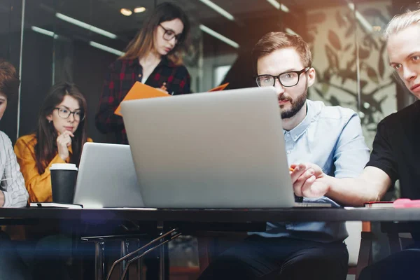 Equipo de socios comerciales que trabajan en ordenadores portátiles en un loft moderno — Foto de Stock