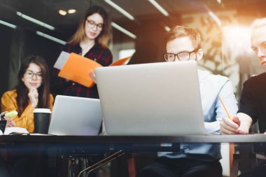 Tasarımcılar ekibi modern bir ofis ahşap bir masada oturur 