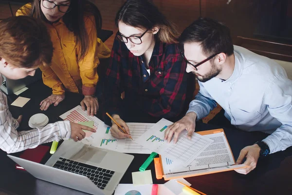 Grupo de estudiantes mujeres y hombres discutiendo diagramas y gráficos — Foto de Stock