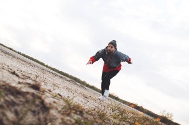 Atlet açık havada yol boyunca çalışır