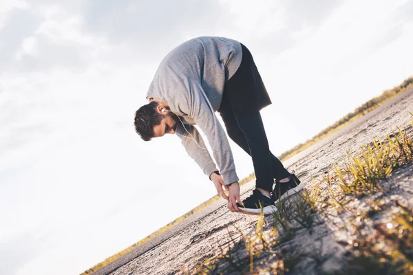 Thlete Warms up. Doing bend over at the sunshine — Stock Photo, Image