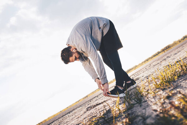 thlete Warms up. Doing bend over at the sunshine