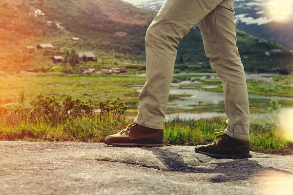 Piernas viajero primer plano sobre un fondo de paisaje de montaña — Foto de Stock