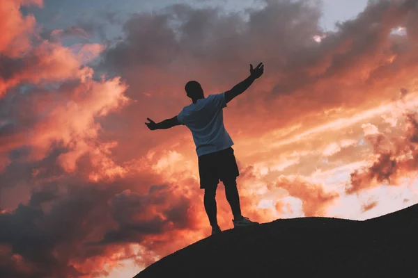 Erfolgreicher und glücklicher männlicher Athlet steht mit erhobenen Armen zum Sonnenuntergang — Stockfoto