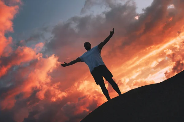 Elleri kadar güzel bir gün batımı gökyüzü doğa ile güçlü bir adam duruyor. Kazanan kavramı — Stok fotoğraf