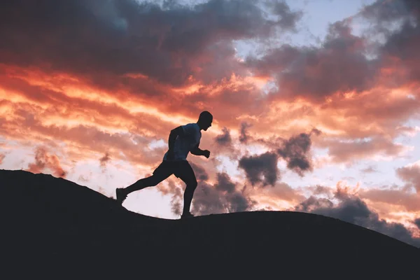 Mann läuft am Abend außerhalb der Stadt. Fitness in der Natur am Abend — Stockfoto