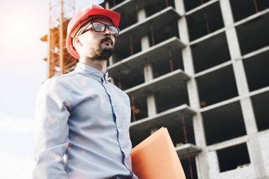 İş adamı ve inşaat mühendisi bina yönetin. Gözlük ve baret inşaat sitesinde mimar