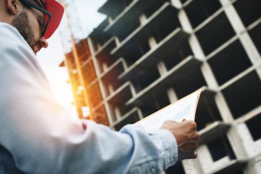 Portre mühendisi kadar kapatın veya mimar inşaat alanında çalışma ve planları tutarak. Mühendislik ve Mimarlık kavramı. Mühendis İnşaat Sanayi izleme