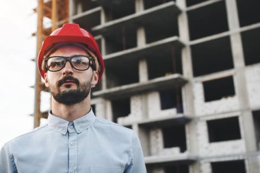Mühendis veya mimar inşaat alanında yeni modern Fabrikası'nın gözlük ve kask giyiyor portresi