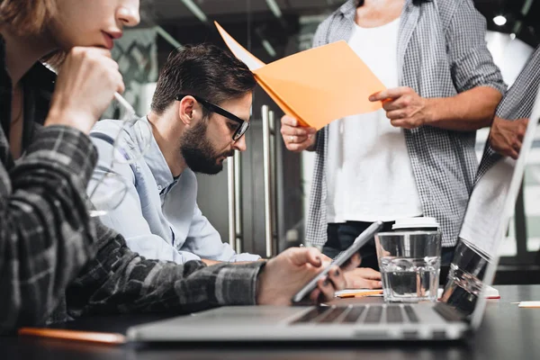 Une équipe d'amis ou de partenaires tient une réunion d'affaires dans le bureau du loft. Équipe d'affaires travaillant avec le studio de démarrage. Utilisation de la tablette numérique et des gadgets — Photo