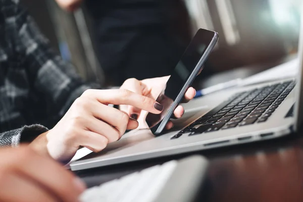 Close Up-weergave van zakenvrouw bezig met moderne smartphone en laptop. Close-up beeld van vrouwelijke handen te typen op de telefoon — Stockfoto