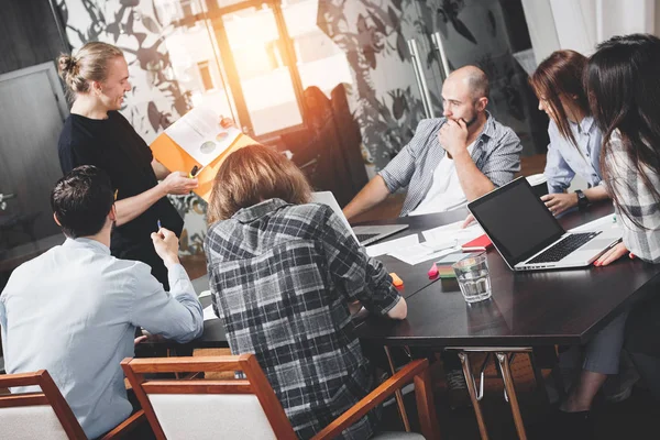 Seis personas trabajando en el loft. Reunión de inicio de coworking. Trabajo en equipo y lluvia de ideas. Pequeñas bengalas intencionales — Foto de Stock