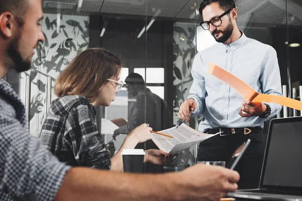 O echipă tânără de colegi discuții de afaceri în biroul modern de coworking. Conceptul de munca in echipa. Fotografia echipei de oameni de afaceri la o întâlnire — Fotografie, imagine de stoc