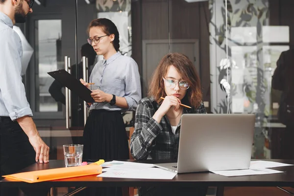 Jóvenes profesionales están trabajando en una nueva startup en una moderna oficina loft. Grupo de gerentes trabaja en dispositivos digitales en el espacio de coworking. Hermosa mujer de negocios que trabaja onl aptop — Foto de Stock