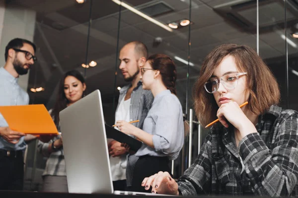 En gruppe kolleger som kommer med nye ideer og utvikler et prosjekt. Brainstorming og møte crew manager i loftsleilighet. Arbeid med digitale innretninger. Bakgrunn lite sløret – stockfoto