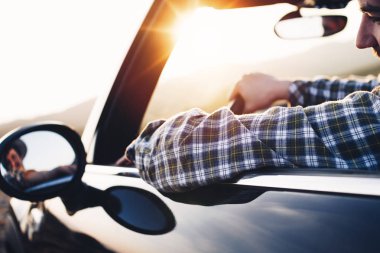 Adam dümen Cabriolet arkasına oturur... ve dikiz aynası görünüyor. Hipster sürüş modern cabriolet