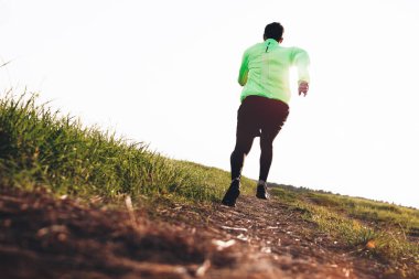 Açık olarak engebeli arazide çevresinde koşu atletik genç adam. Spor sıkı giysi