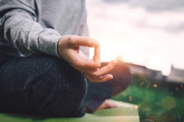 Pratik yoga kentsel alanda genç kadın portresi. Güzel kız Lotus pozisyonu ve meditasyon pratik. Arka plan bulanık fişekleri etkisi