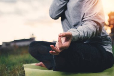 Kızı pratik yoga kentsel alanda close-up. Genç kadın Şehir Parkı içinde meditasyon. Arka plan bulanık, huzur ve rahatlama kavramı