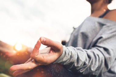Genç kadın batımında yoga ve meditasyon asana kentsel alan veya şehir Park pratik görünümünü kapatın. Yatay, bulanık arka plan ve güneş ışığı