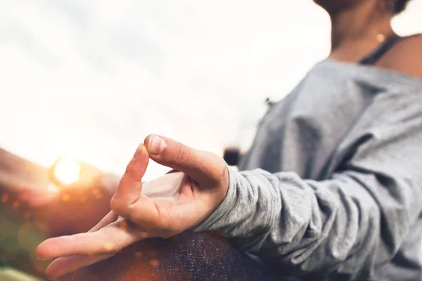 Nahaufnahme einer jungen Frau, die Yoga und Meditation Asana im Stadtraum oder Stadtpark bei Sonnenuntergang praktiziert. horizontaler, verschwommener Hintergrund und Sonnenlicht — Stockfoto