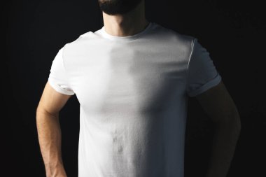 Genç adam beyaz t-arka plan siyah duvara kısa. T-shirt kas modeli erkek üzerinde kapat