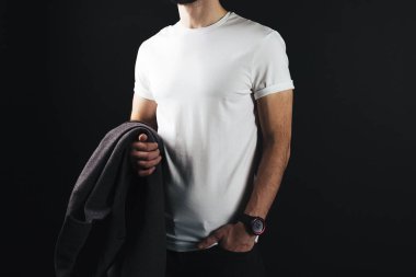 Boş beyaz tshirt atletik erkek vücut yakın çekim üzerinde. Adam wearning beyaz t-shirt ve bir kat elinde tutuyor