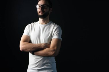 Gülümseyen adam geçiş elleri göğsünde beyaz boş t-shirt giyen sakallı. Ön yüzü