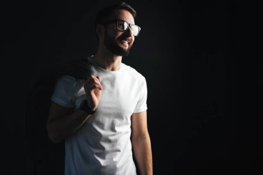 Koyu arka plan üzerinde beyaz boş tişörtü giyen onun omuz şık bir ceket ile gözlüklü ince sakallı hippi gülümseyen