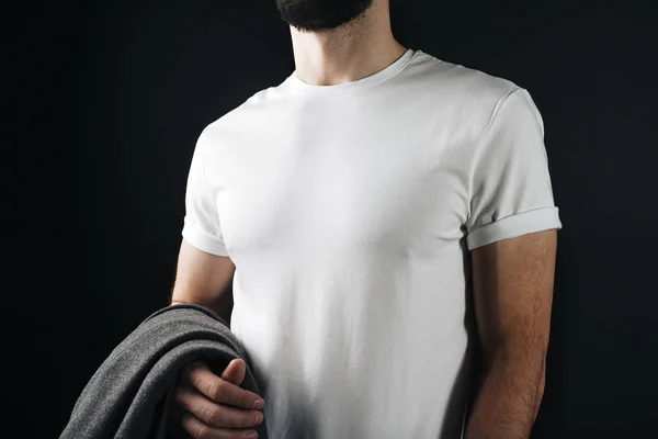 Zbliżenie zdjęcie biały t-shirt na pewien szczupły ciało samców na ścianie czarny — Zdjęcie stockowe