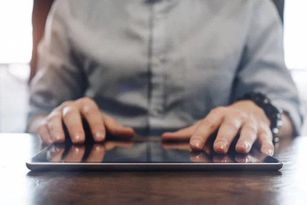 Accountmanager werken en te typen op moderne tablet. Tablet close-up op houten bureau in een moderne open kantoor. Mannen handen aanraken van de scherm-tablet — Stockfoto