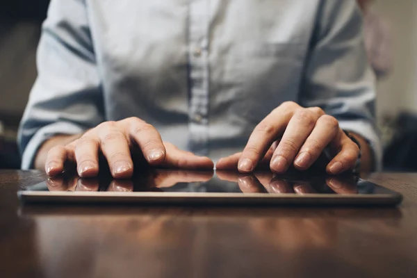 Zár-megjelöl kilátás-a gépelés a képernyő modern tabletta férfi kezét. Számítógép touch pad, fa tábla — Stock Fotó