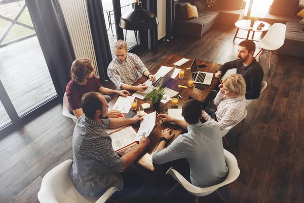 Trabajo en equipo en un nuevo proyecto de negocio en un loft. Compañeros de trabajo de grupo que toman grandes decisiones de negocio.Los gerentes creativos discuten concepto de trabajo oficina moderna — Foto de Stock