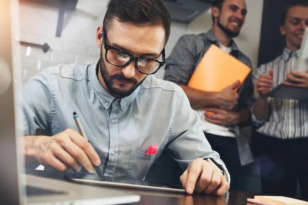 Bearded glasses manager analyzes earnings of shares on tablet screen. Architect draws project with stylus on screen of modern tablet. Concept coworking office — Stock Photo, Image